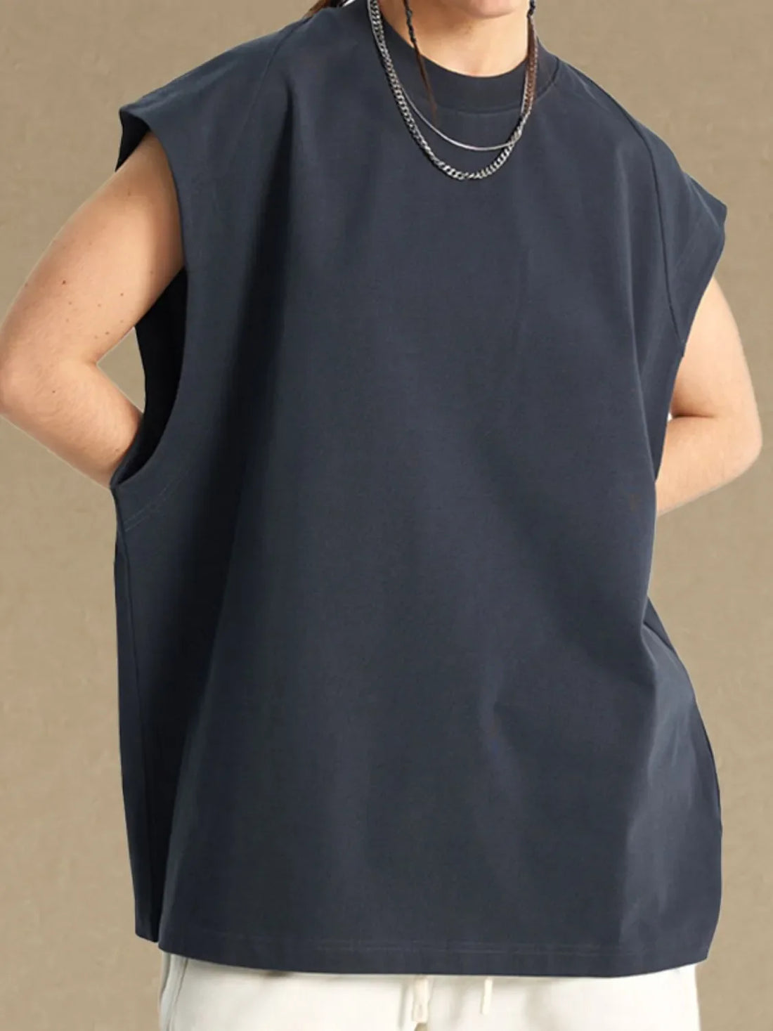 Raglan shoulder sleeveless top in dark gray with crew neck and pockets.