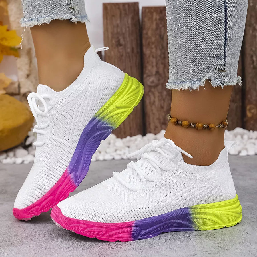 White mesh lace-up sneakers with a pink, purple, and neon yellow gradient sole.
