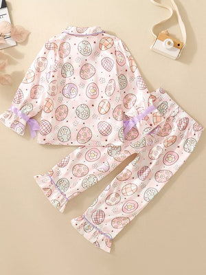 Toddler pajama set with pastel Easter egg print, button-down top, and ruffled cuffs.