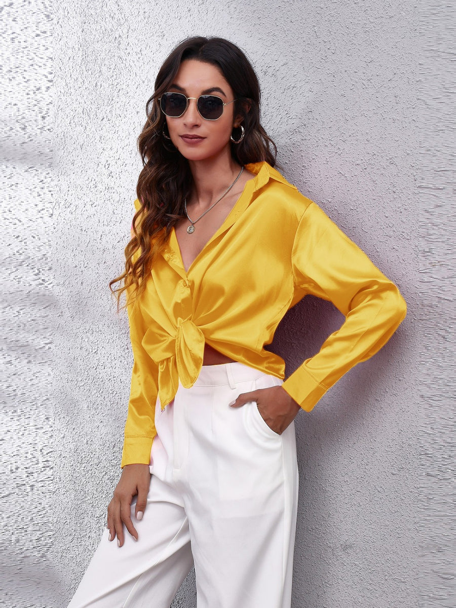 Satin button-up shirt in Mustard, tied at the waist, with a collared neckline and long sleeves.