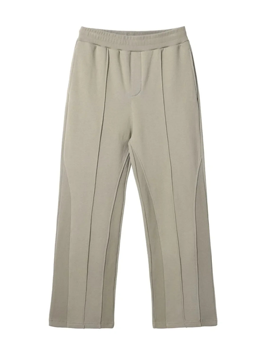Beige lounge trousers with vertical seam details and a wide leg.
