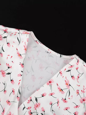 White floral print V-neck wrap dress with pink flowers and green stems.
