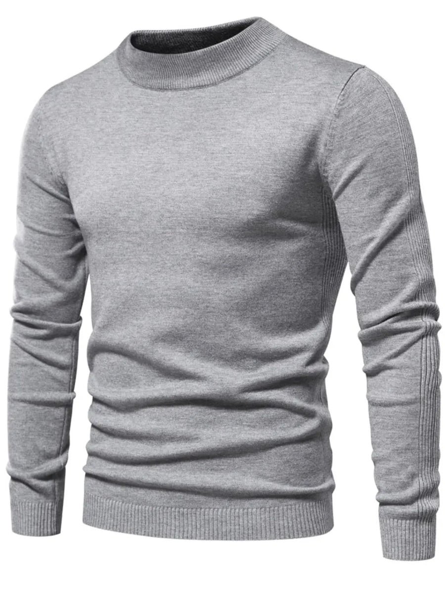 Gray ribbed mock neck sweater with sculpted shoulder detail and ribbed cuffs and hem.