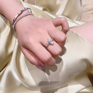 Silver ring with marquise cut diamond on hand with bracelets