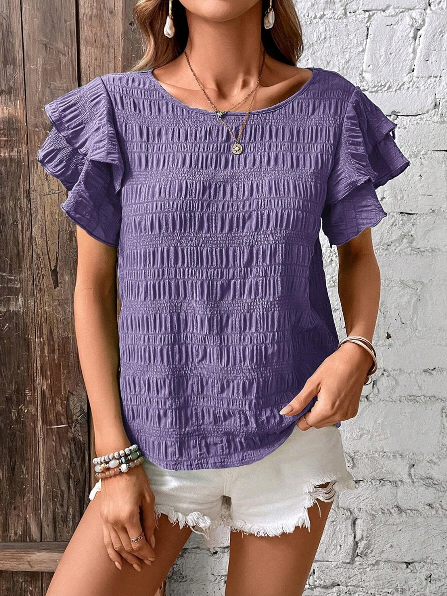 Purple smocked blouse with ruffle sleeves and textured fabric.
