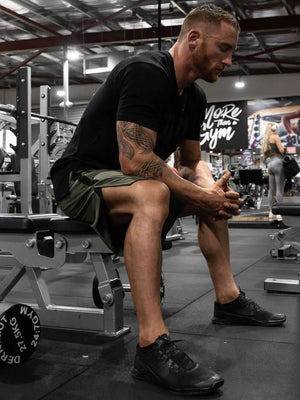 Performance panel shorts in army green with black accents and logo detail.