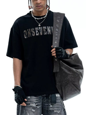 Black oversized cotton t-shirt with a distressed silver logo graphic and crew neck.