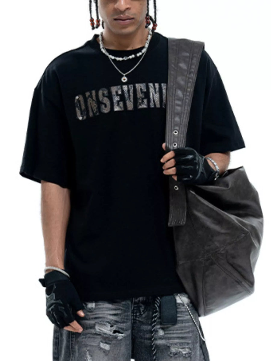Black oversized cotton t-shirt with a distressed silver logo graphic and crew neck.