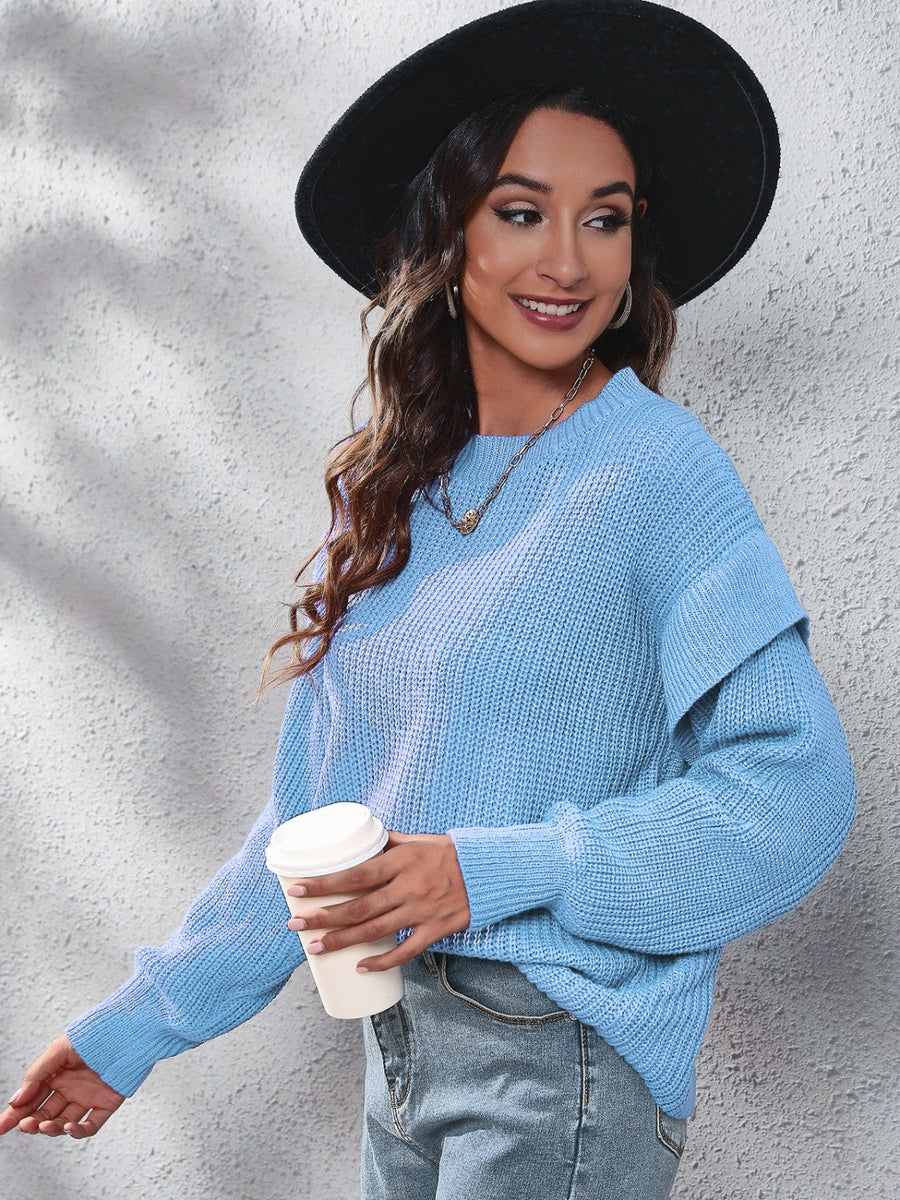 Pastel blue ribbed knit pullover sweater with ruffled sleeves and a crew neck.