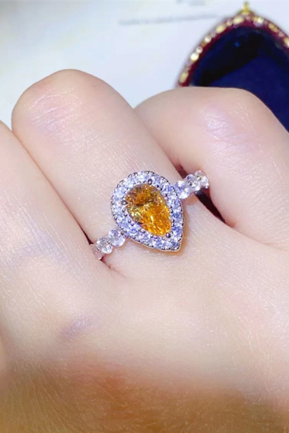 Halo pear-cut amber gemstone ring with diamond halo and band in gold.