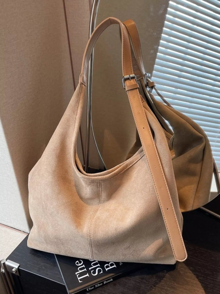 Khaki suede hobo bag with adjustable strap and silver buckle detail.