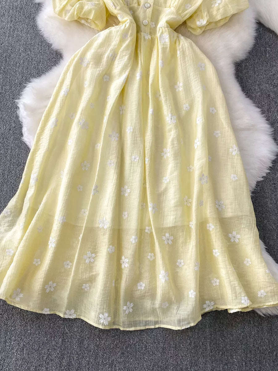 Yellow embroidered puff sleeve midi dress with button detail and A-line skirt.