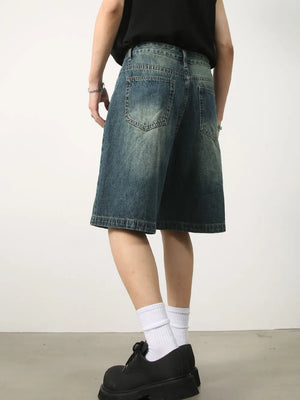 Baggy denim bermuda shorts in washed light blue with buttoned closure and distressed details.