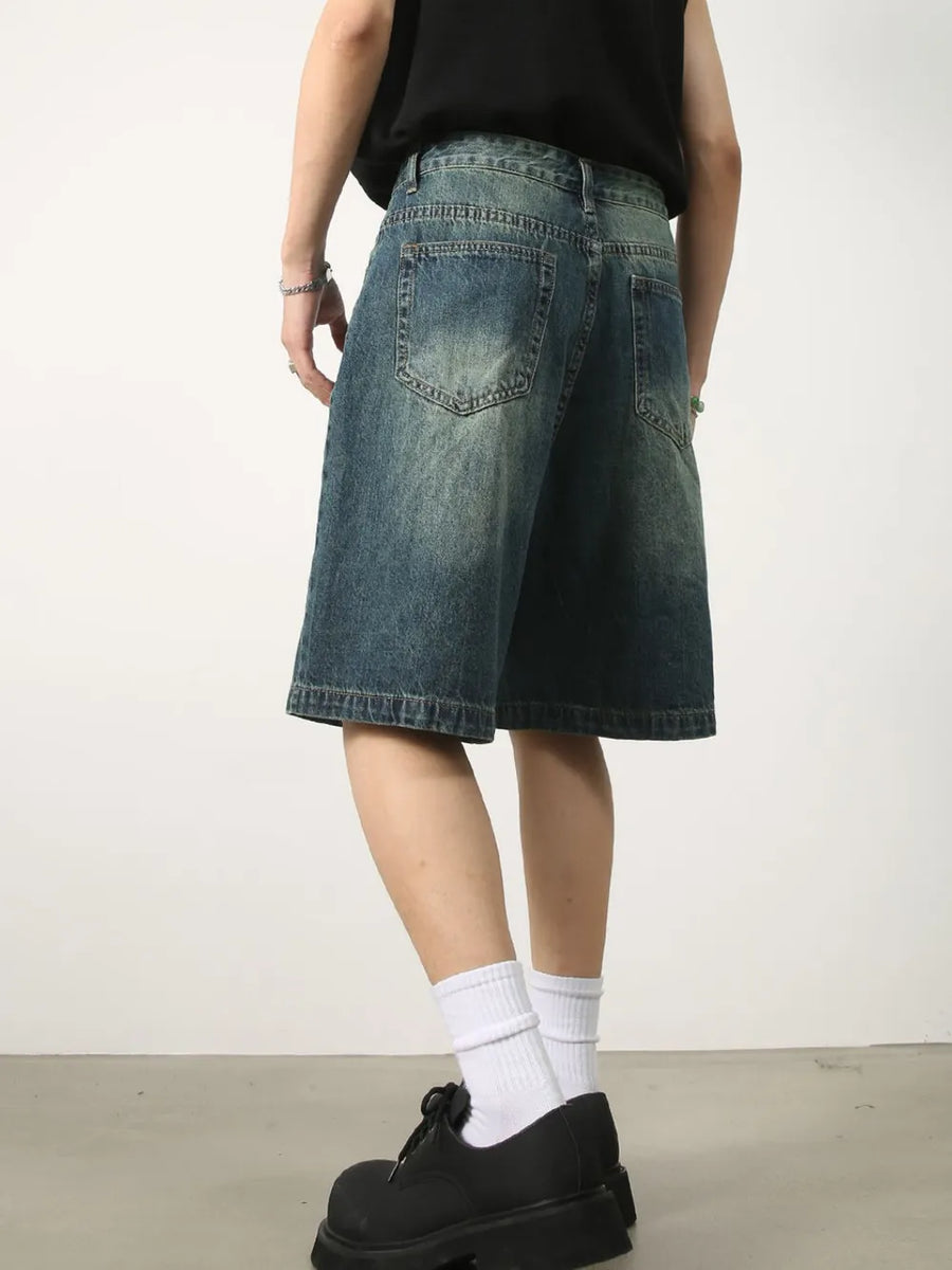 Baggy denim bermuda shorts in washed light blue with buttoned closure and distressed details.