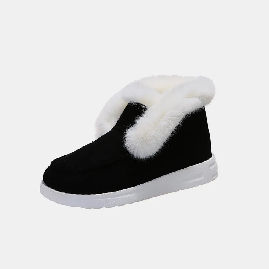 Black suede slip-on booties with white shearling trim and white sole.