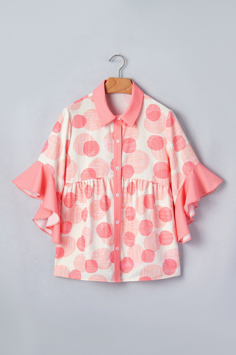 White and pink polka dot babydoll blouse with ruffle sleeves and button front.