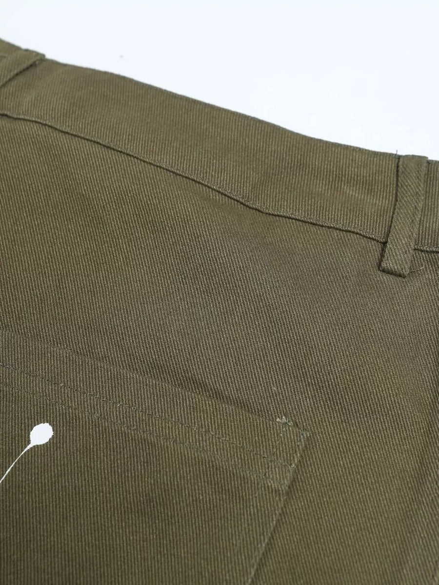 Olive green cotton cargo pants with white paint splatter detail and button fly.