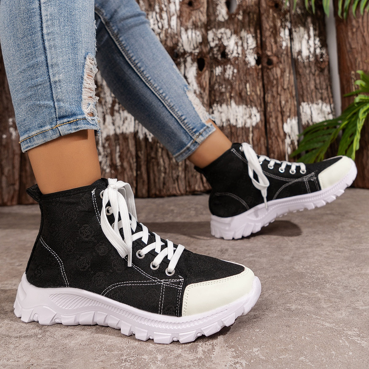 Black canvas high-top sneakers with white laces and chunky soles.