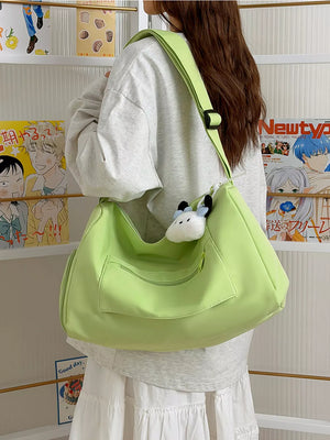 Light green travel bag with adjustable strap and front pockets, worn by a woman.