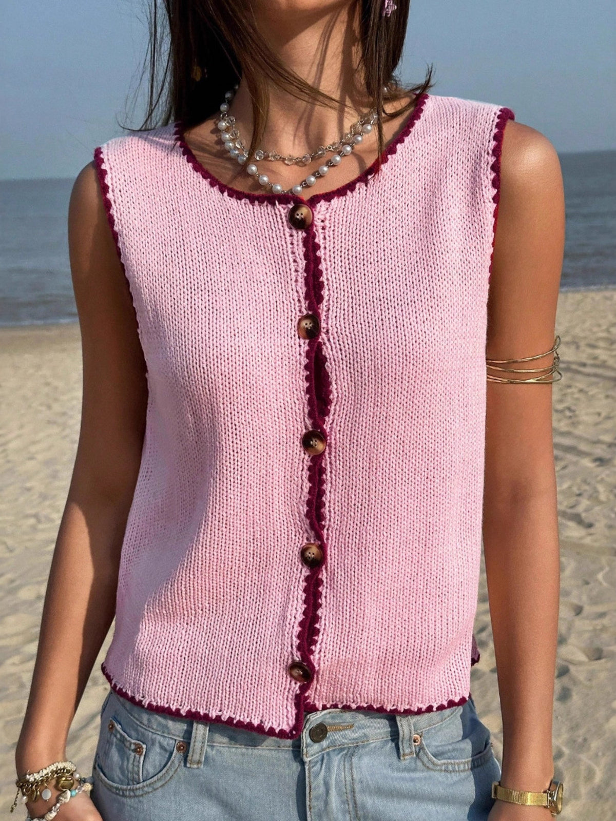 Pink button-down sweater vest with contrast trim and buttons