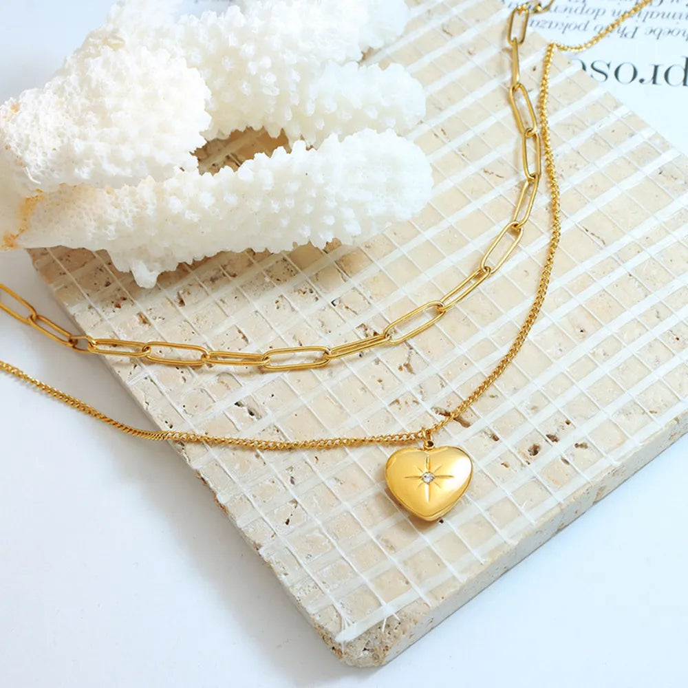 Gold layered necklace with paperclip chain and heart pendant with crystal accent