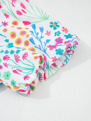 Textured floral bubble sleeve blouse with abstract floral print in pink, blue, and yellow on white.