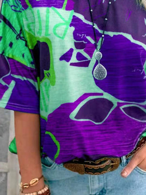 Casual t-shirt with brushstroke stripes in purple and green, short sleeves, and a crew neck.
