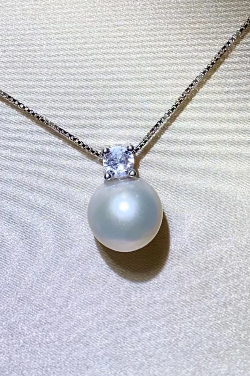 Solitaire pearl pendant necklace in silver sterling with a clear cubic zirconia accent.