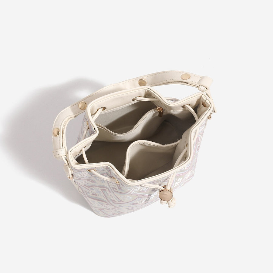 crossbody bag in cream with geometric and drawstring closure