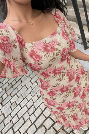 Charming floral midi dress with square neckline, flutter sleeves, and ruffled hem.