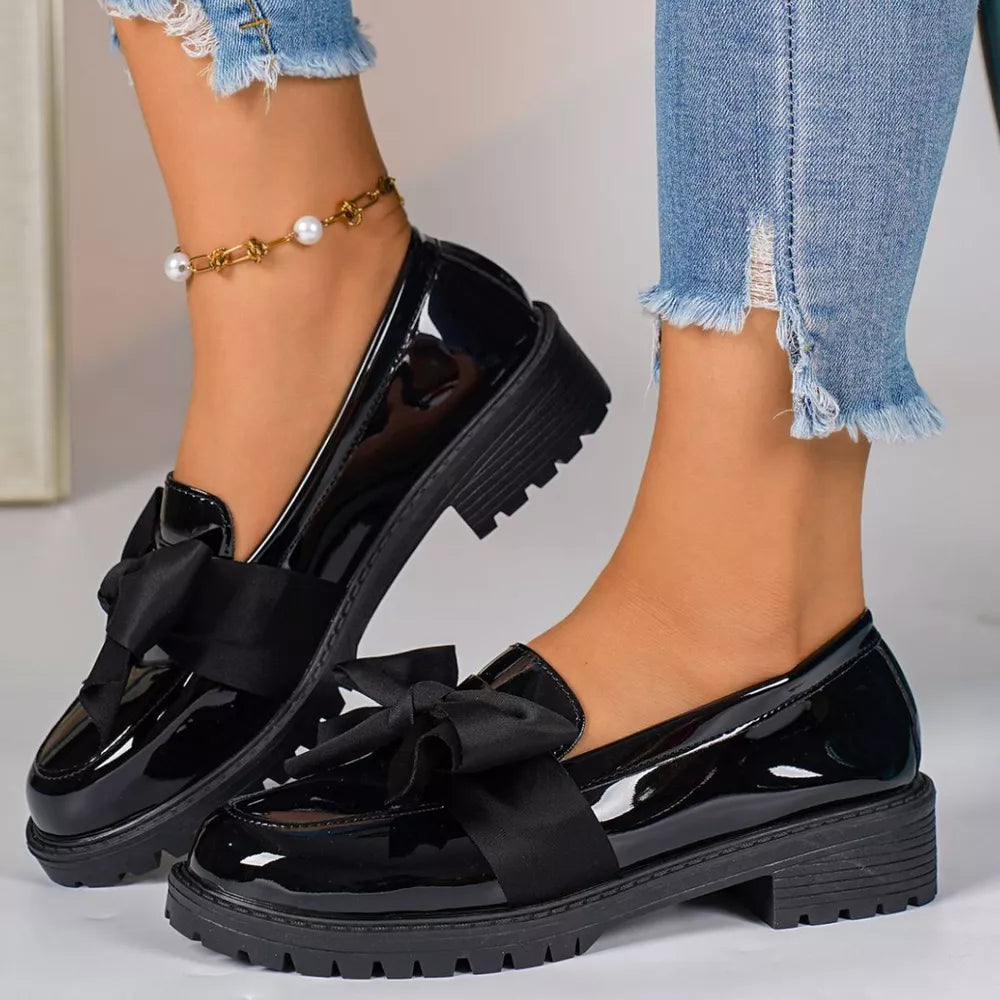 Black patent loafers with bow detail and chunky sole.