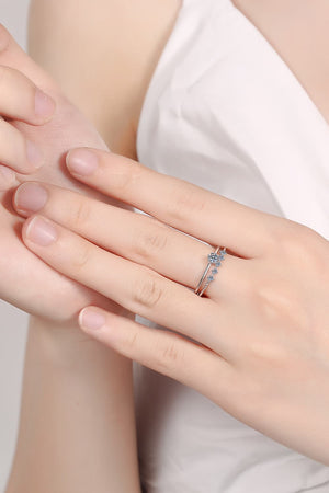 Silver layered rings with moissanite accents on a hand.