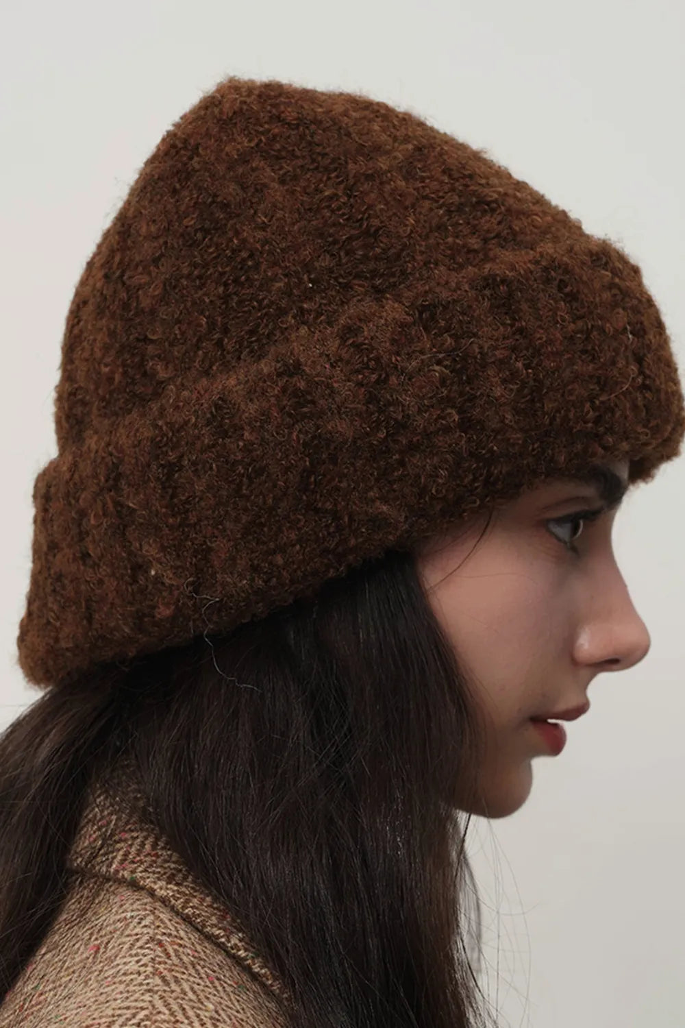 Textured bouclé knit beanie in chocolate brown, shown on a model.