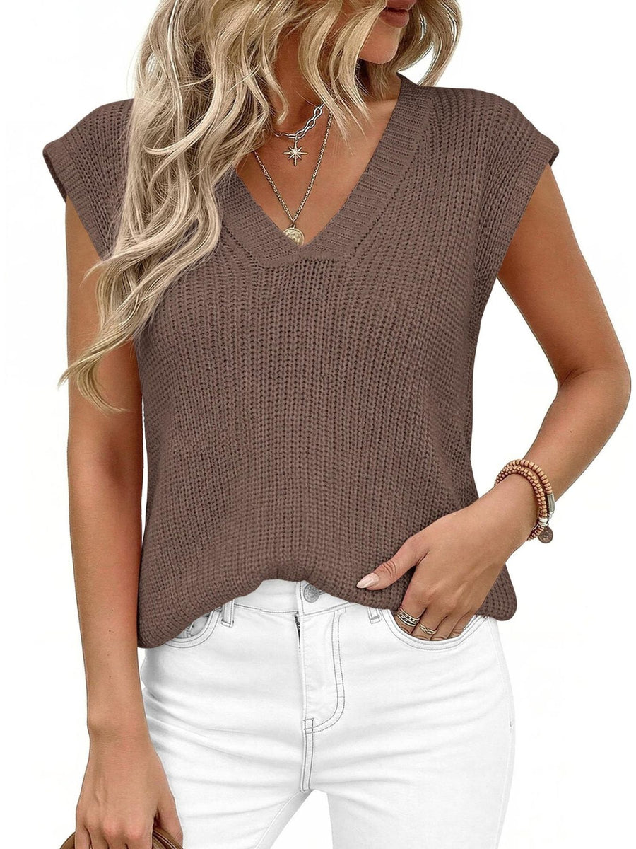 Textured brown V-neck sweater vest with cap sleeves, styled with white jeans.