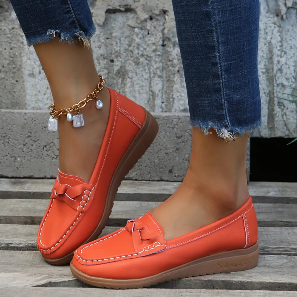 Orange-Red leather loafers with braided detail and white stitching.