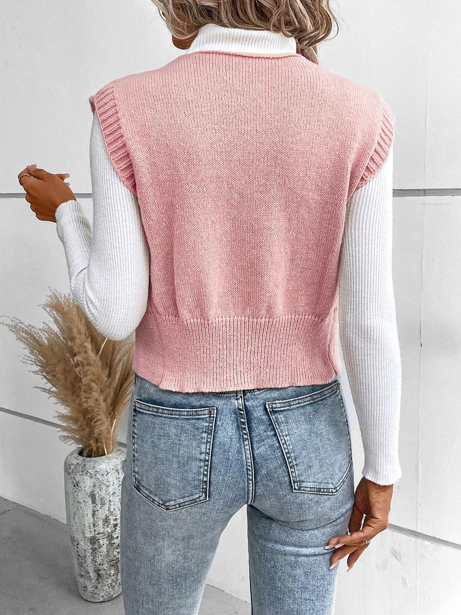 Dusty pink knit vest with ribbed trim and crew neck, worn over a white turtleneck.