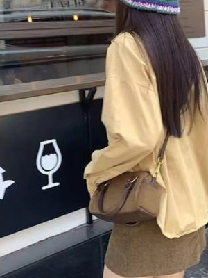 Vintage barrel crossbody bag in coffee brown with dual top handles and a shoulder strap.