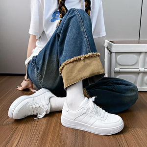 White minimalist platform sneakers with perforated details and a lace-up closure.