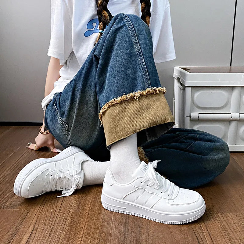 White minimalist platform sneakers with perforated details and a lace-up closure.