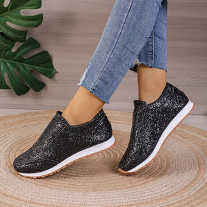 Black glitter slip-on flats with round toe and white soles.