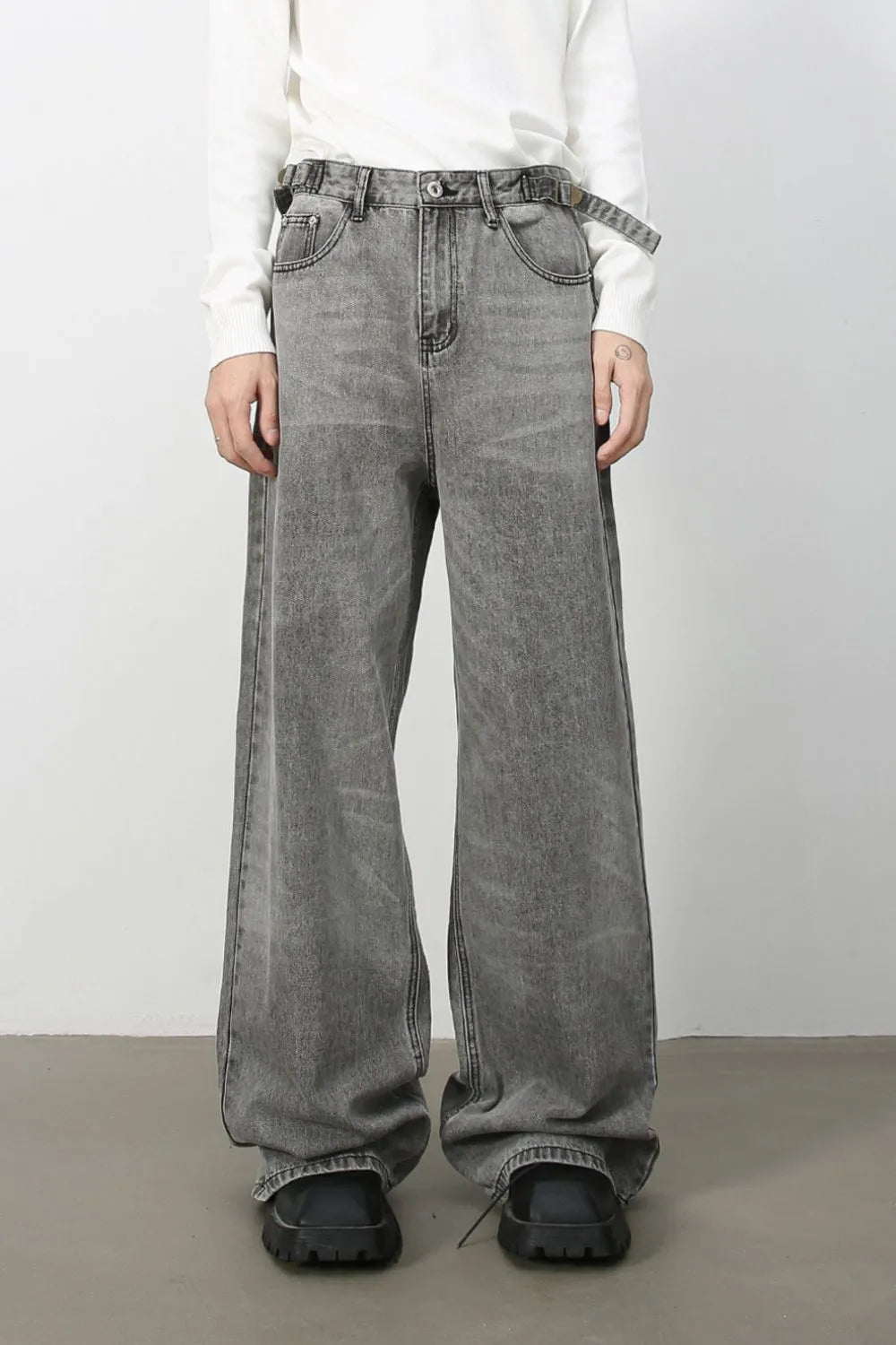 Wide-leg dark gray washed denim jeans with belt and relaxed fit.