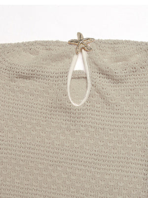 Beige knit maxi dress with cutout detail and starfish embellishment.