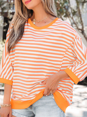 Oversized orange and white striped cotton t-shirt with 3/4 sleeves and crew neck.