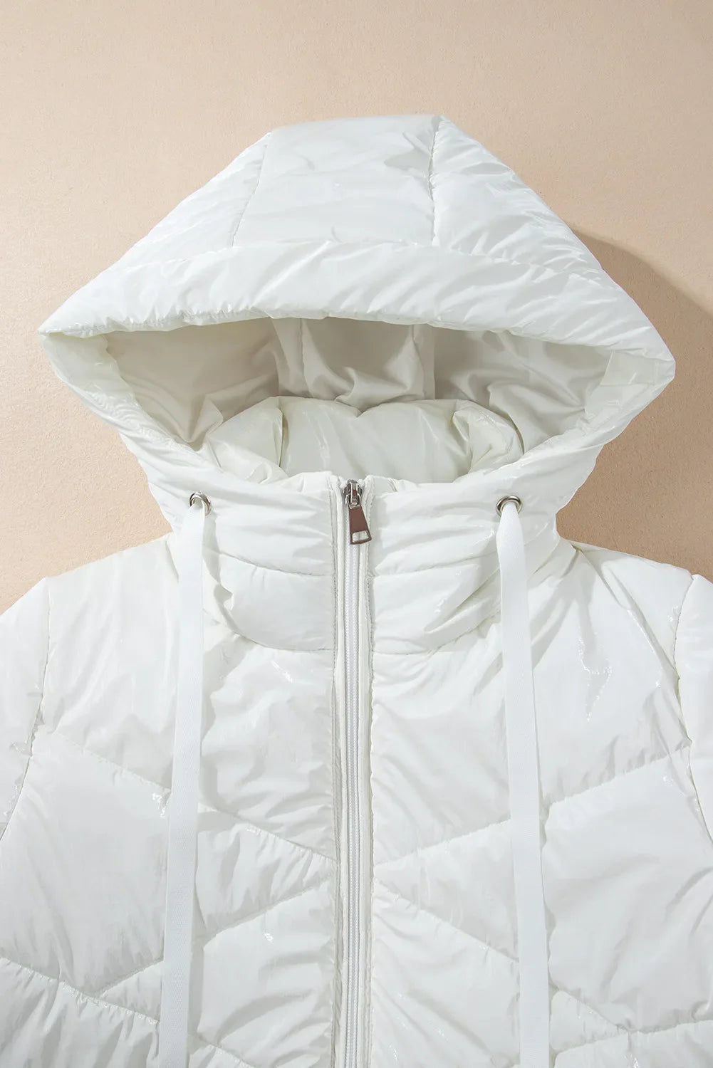 White glossy quilted hooded puffer jacket with a zipper and drawstring hood.