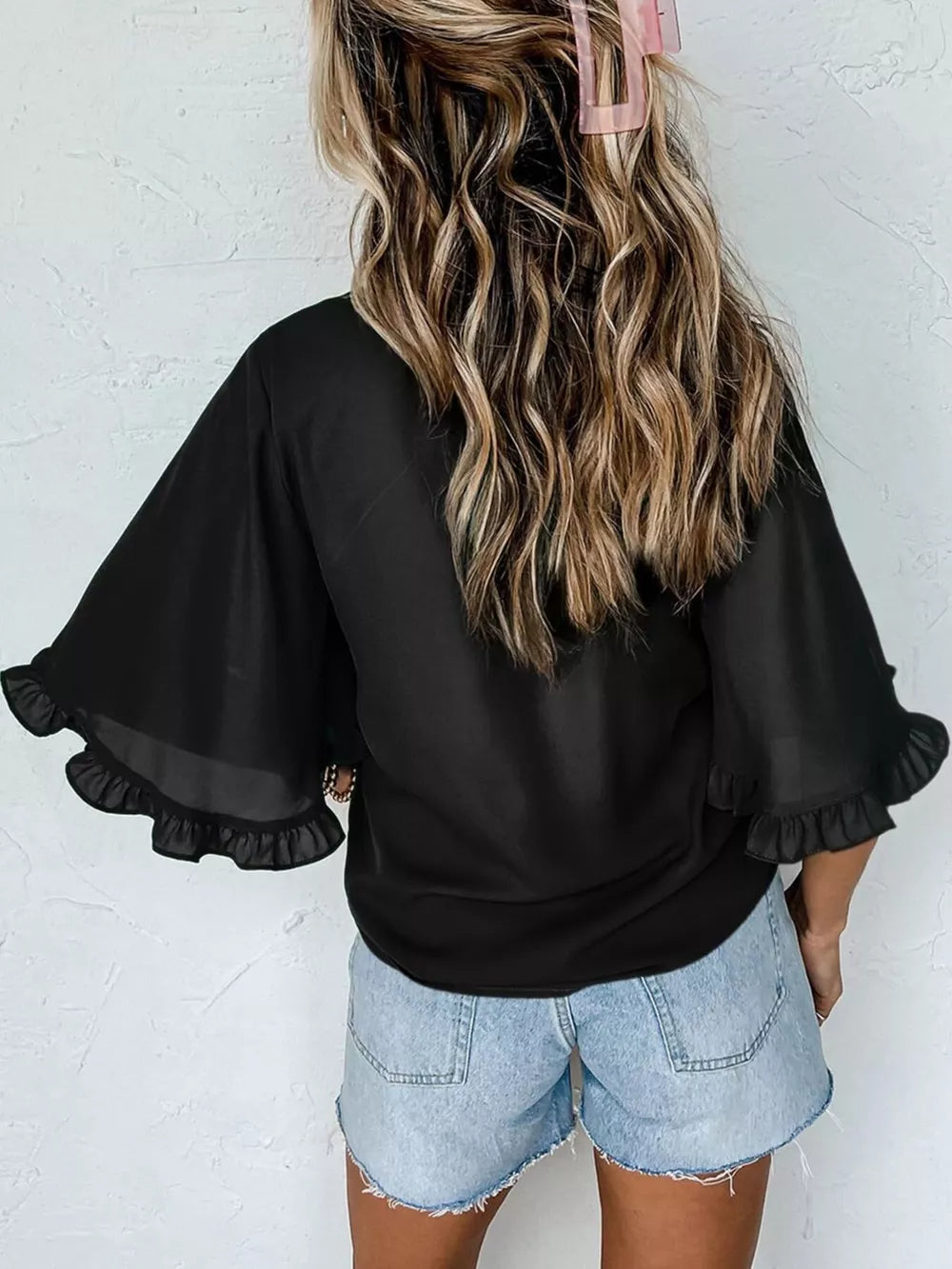 Black ruffled mock neck half sleeve shirt with sheer flutter sleeves.