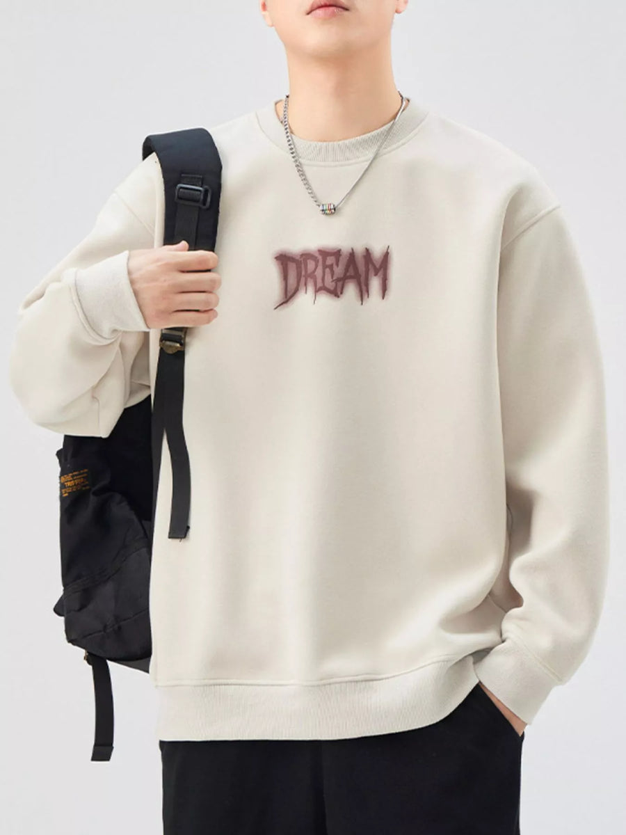 Oversized cream crew-neck sweatshirt with "DREAM" graphic, cotton blend, casual wear.