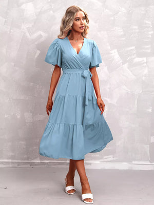 Light blue tiered midi dress with flutter sleeves, V-neck, and belted waist