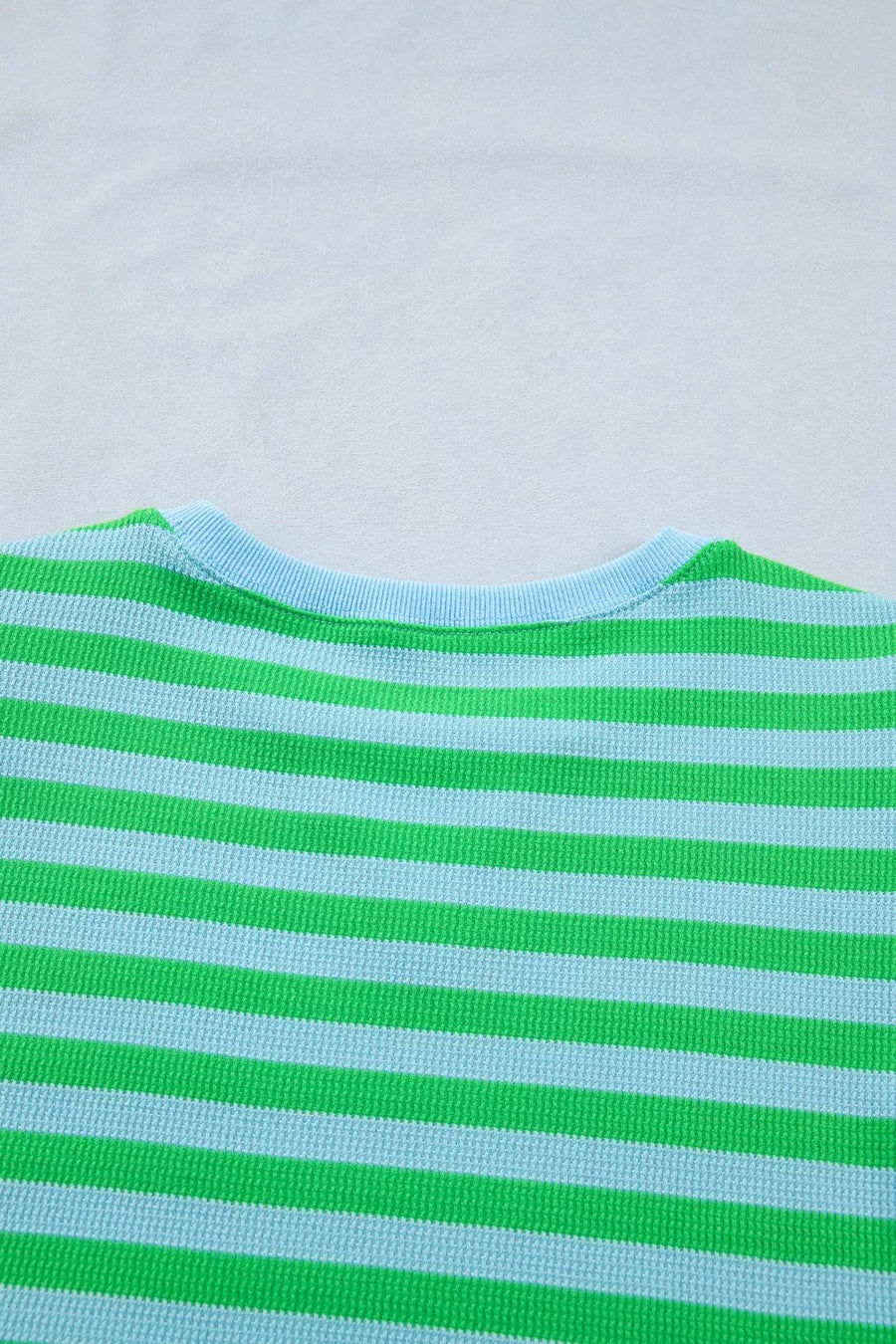 Striped crewneck sweater in green and light blue waffle knit fabric.
