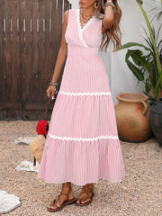 Lace-trimmed striped maxi dress in blush pink with a V-neck and tiered skirt.