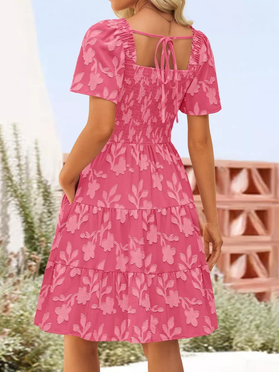Smocked mini dress in Strawberry with floral embroidery, tiered skirt, puff sleeves, and tie-back square neck.